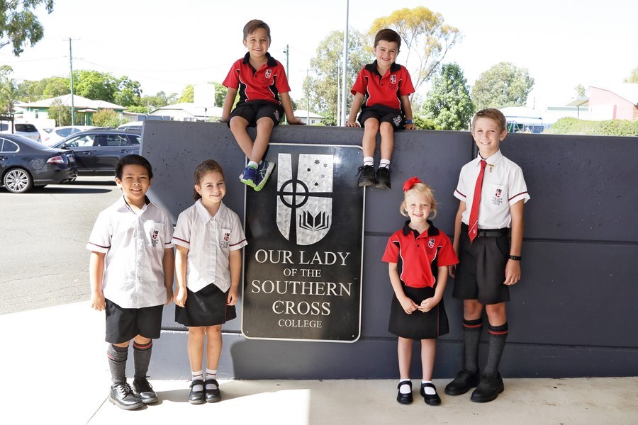 Students in front of school sign 